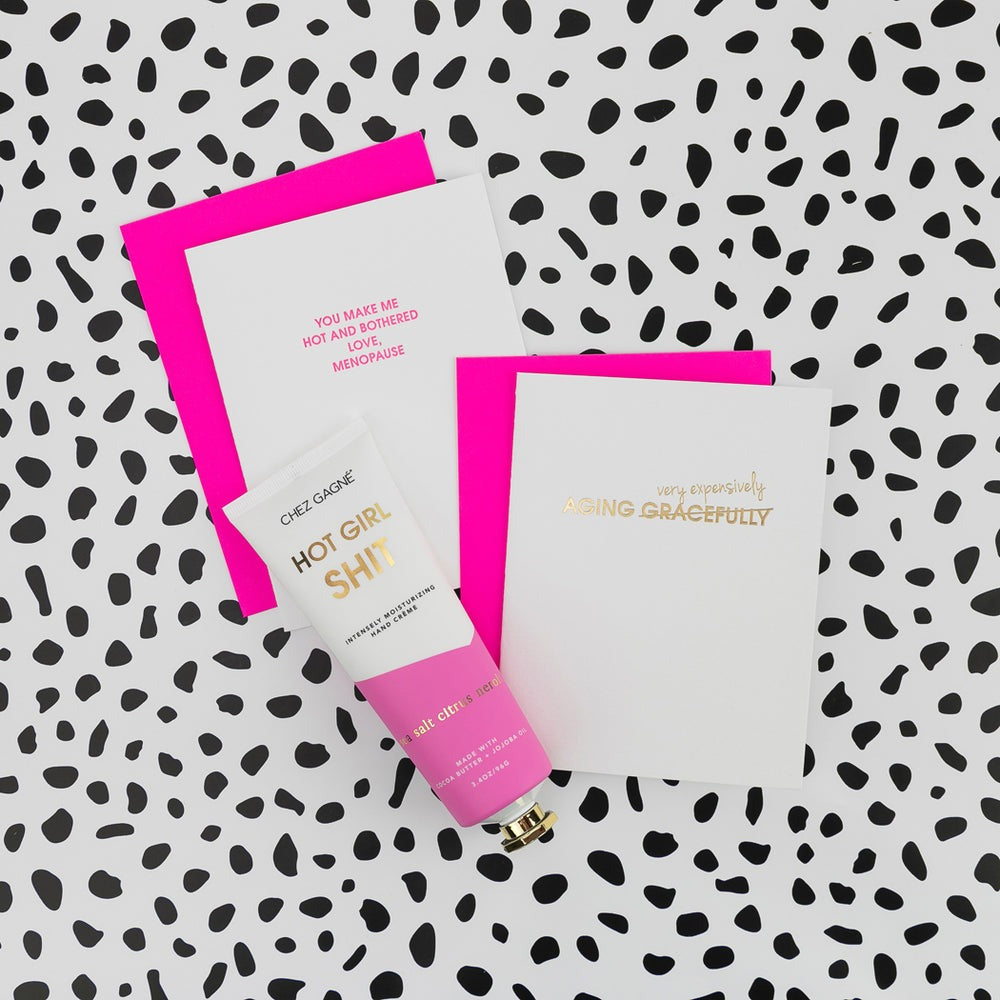 Hand cream with pink cap and packaging on a patterned background