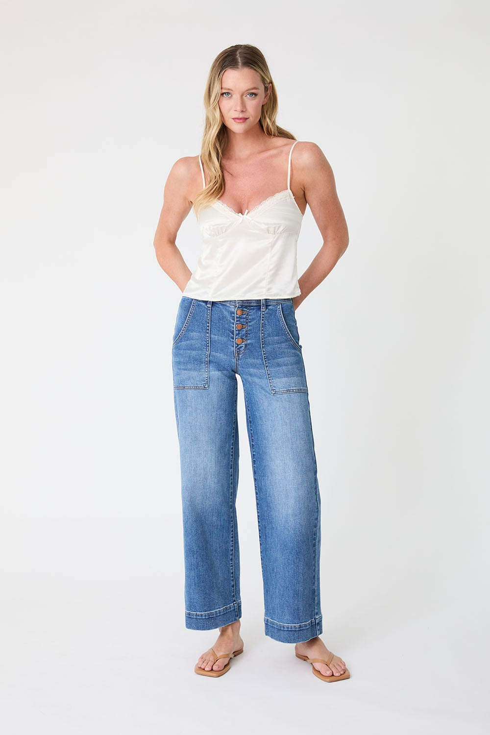 Woman wearing a white top and blue jeans on a white background