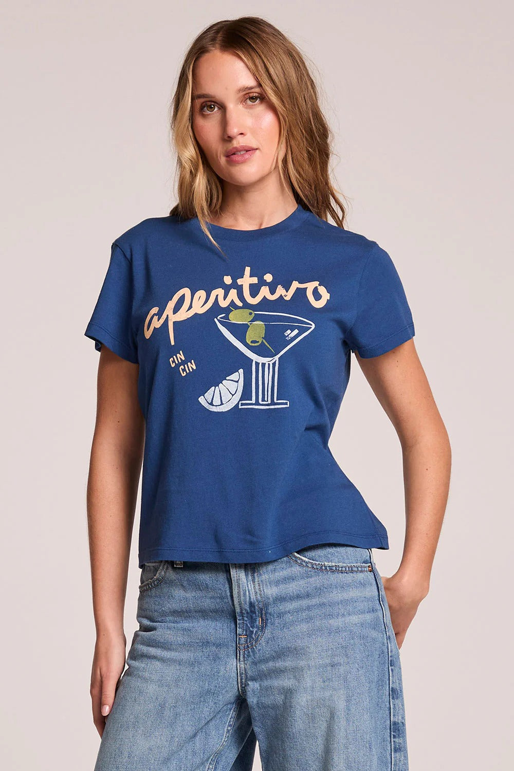 Woman wearing a blue t-shirt with a graphic design on a plain background