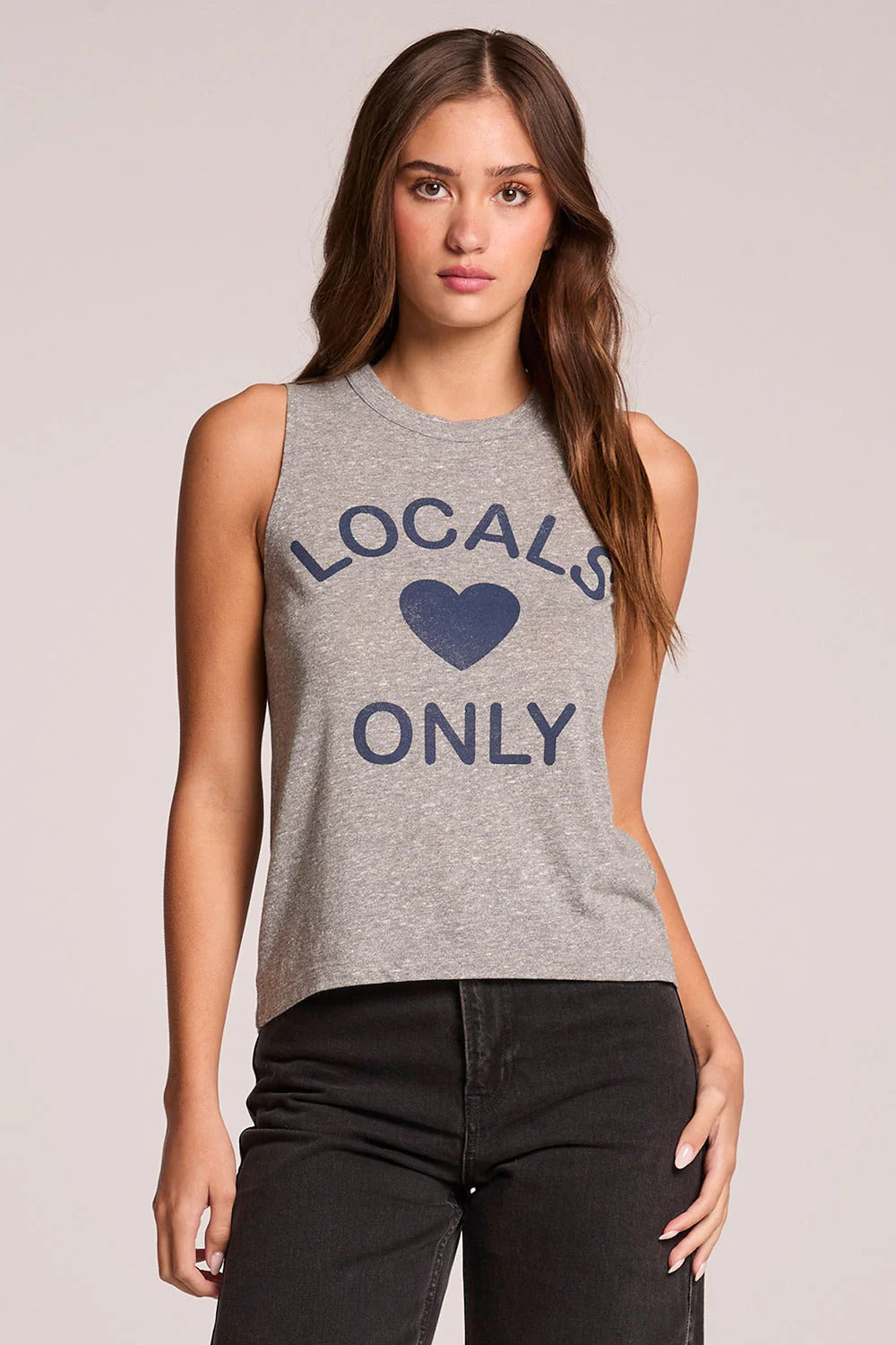 Woman wearing a gray tank top with 'Locals Only' text and heart graphic on a plain background