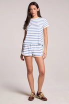 Woman wearing a striped t-shirt and shorts set on a plain background