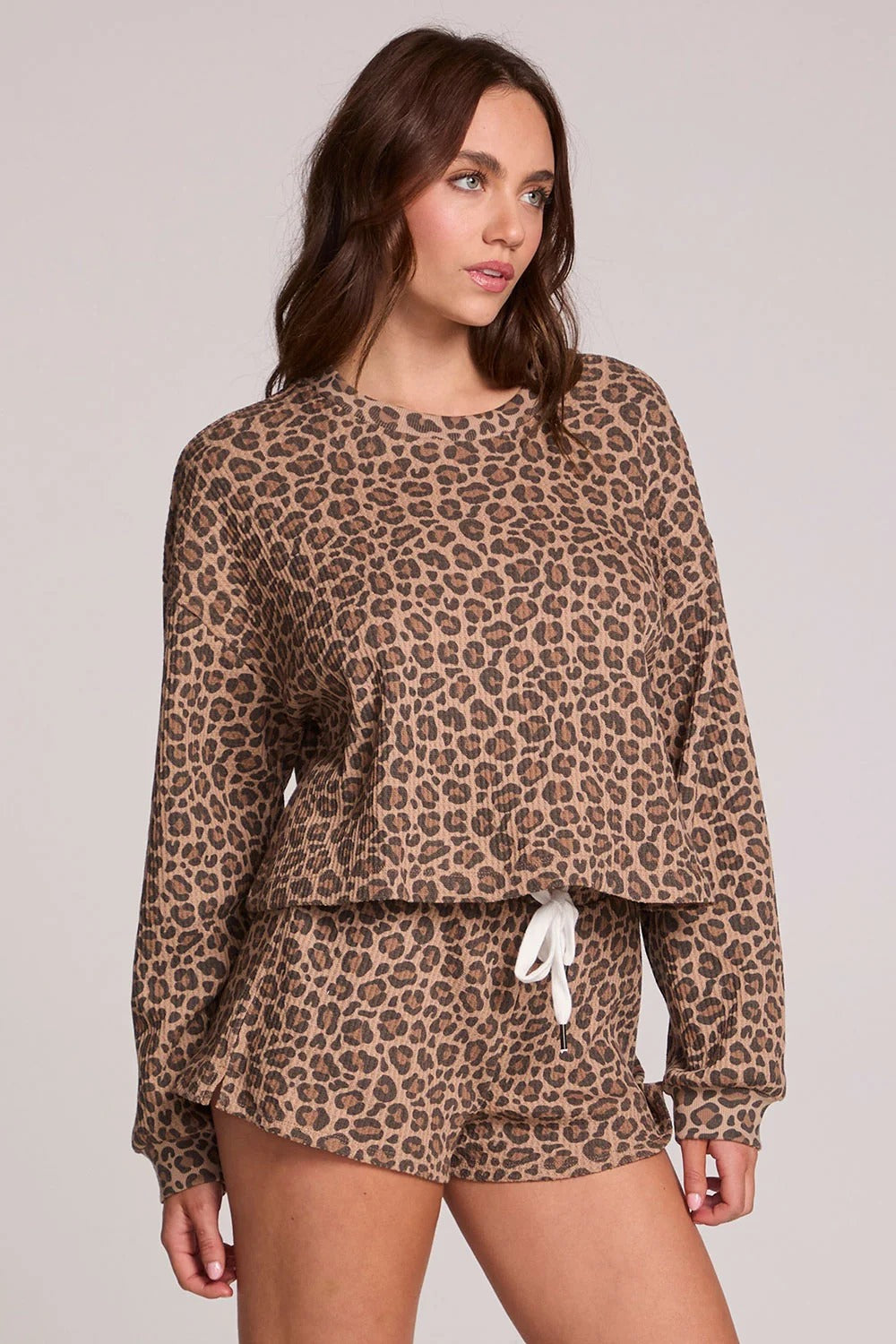 Person wearing a leopard print outfit on a plain background