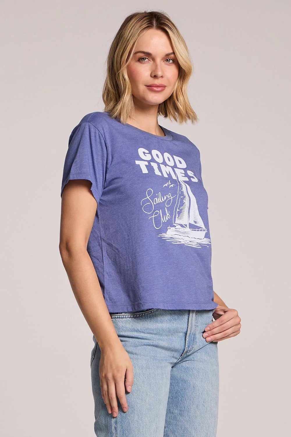 Woman wearing a blue t-shirt with 'Good Times at Sailing Club' text and graphic on a plain background