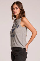 Woman wearing a gray sleeveless shirt with text on a plain background