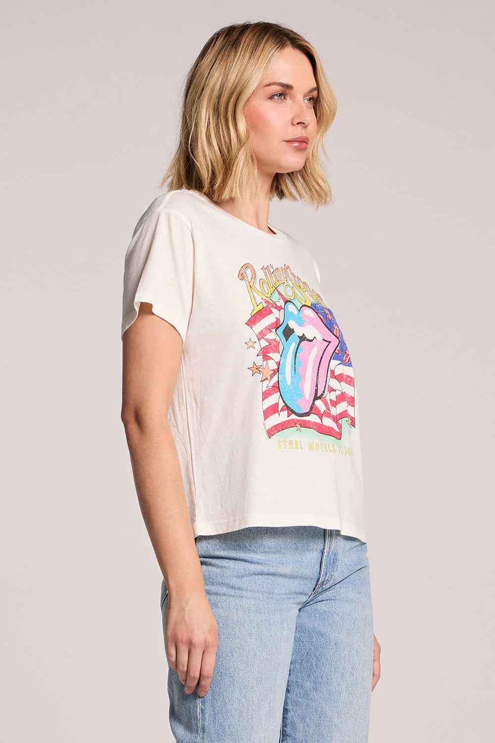 Woman wearing a t-shirt with a colorful graphic design on a plain background