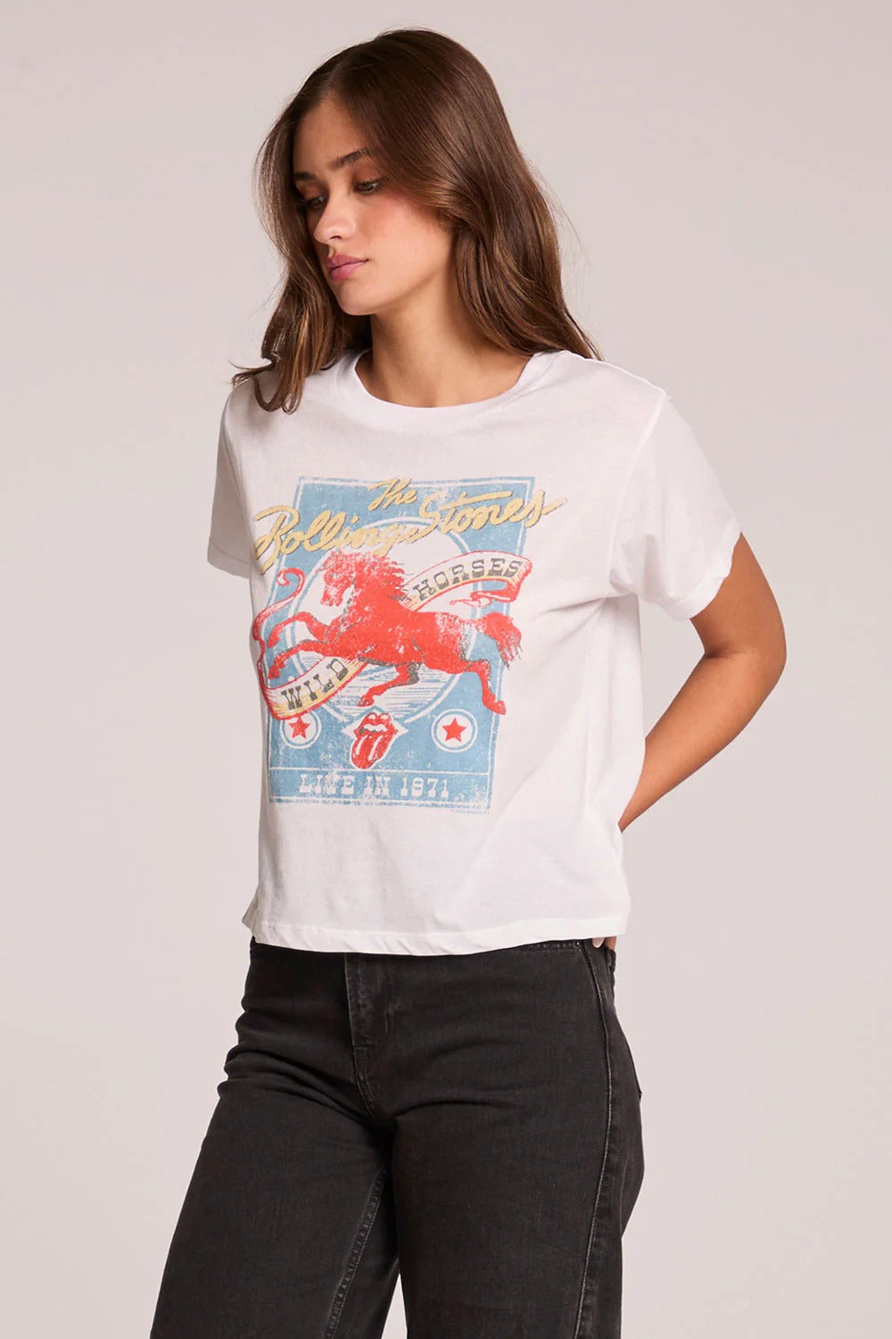 Woman wearing a white t-shirt with a graphic design on a plain background