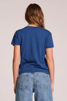 Person wearing a blue t-shirt and jeans on a plain background