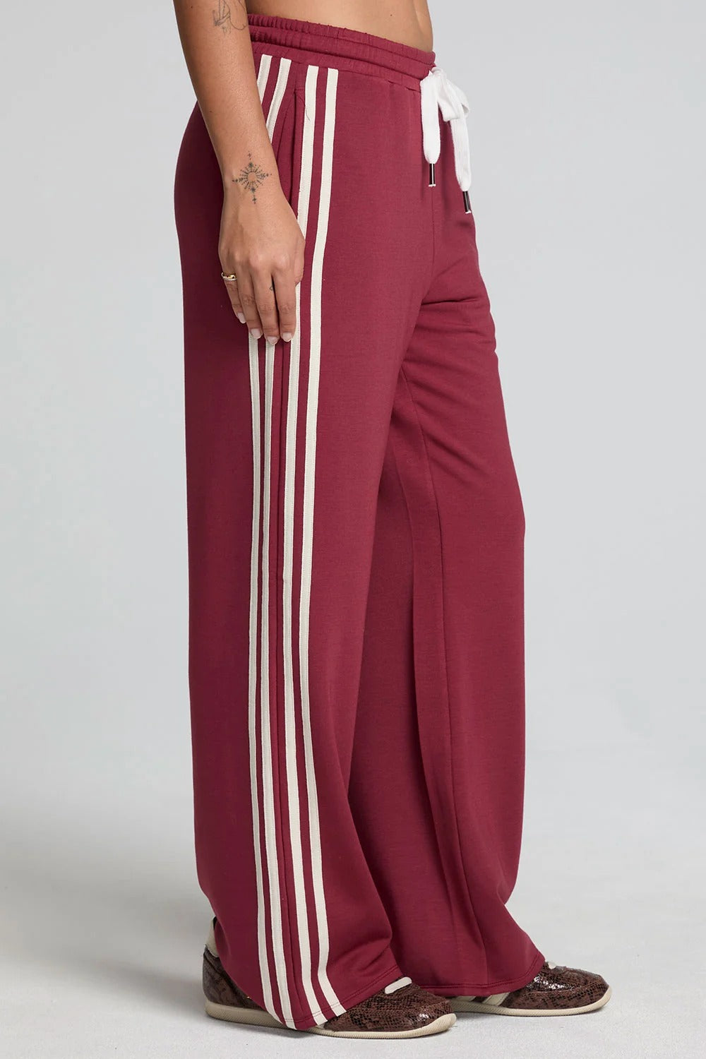 Maroon pants with white stripes on a plain background