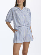 Woman wearing a blue and white striped dress on a white background