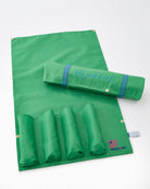 Green play mat with rolled-up mat and pouch on a white background