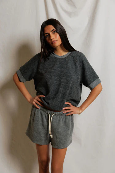 Woman wearing a gray outfit with a plain background