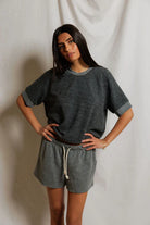 Woman wearing a gray outfit with a plain background