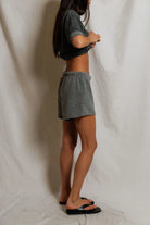 Person wearing a gray outfit standing against a plain white background