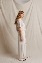 Person wearing a white outfit standing against a plain white background