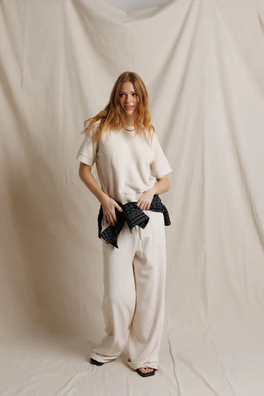 Woman wearing a white outfit against a plain background
