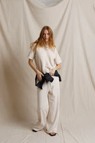 Woman wearing a white outfit against a plain background