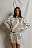 Woman wearing a striped outfit against a plain background