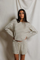 Woman wearing a striped outfit against a plain background