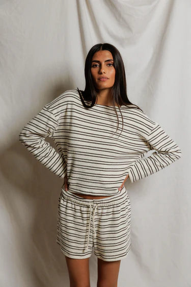 Woman wearing a striped outfit against a plain background