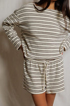Person wearing a striped long-sleeve top and shorts set against a plain background