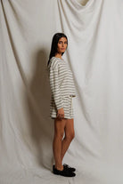 Woman wearing a striped dress against a plain white background