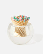 Clear glass holder with colorful matchsticks on a white background