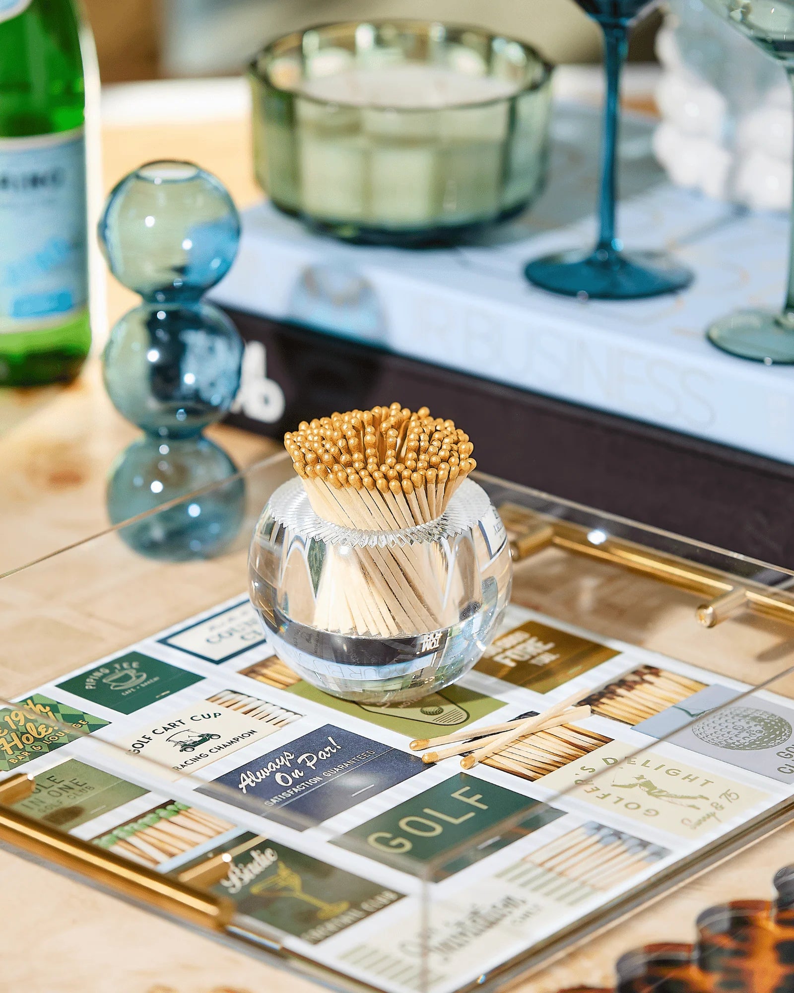 Glass container with matches on a decorative tray with matchbooks