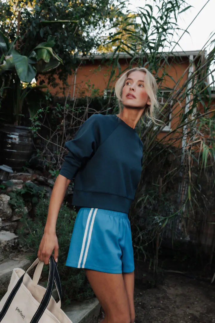 Woman in blue outfit with white stripes outdoors