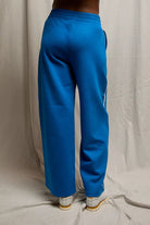 Blue pants worn by a person on a plain background