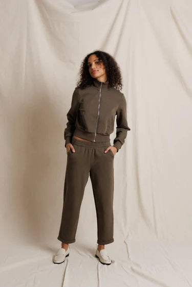 Person wearing a brown tracksuit against a plain background