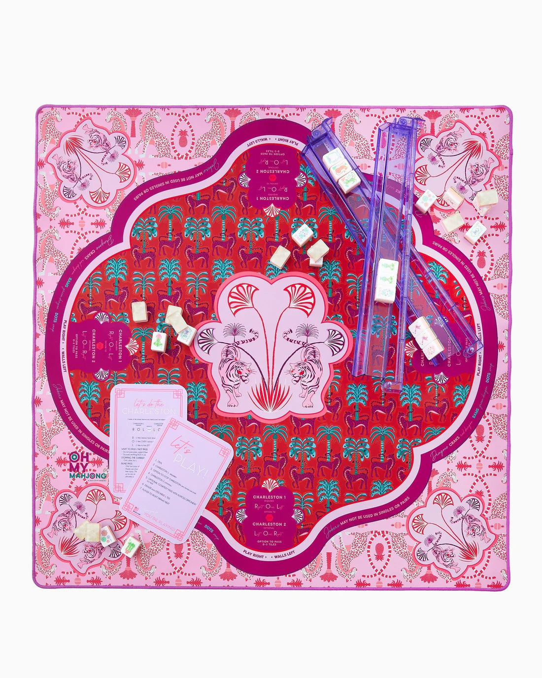 Decorative board with floral design, clear plastic items, and cards on a pink and red patterned background