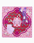 Decorative board with floral design, clear plastic items, and cards on a pink and red patterned background