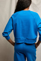 Person wearing a blue outfit against a neutral background