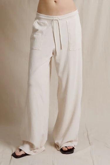 Beige wide-leg pants worn by a person on a neutral background