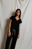 Woman wearing a black outfit against a plain background