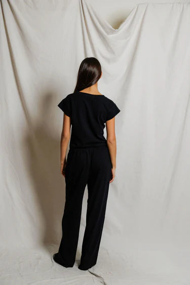 Person wearing a black outfit against a plain white background