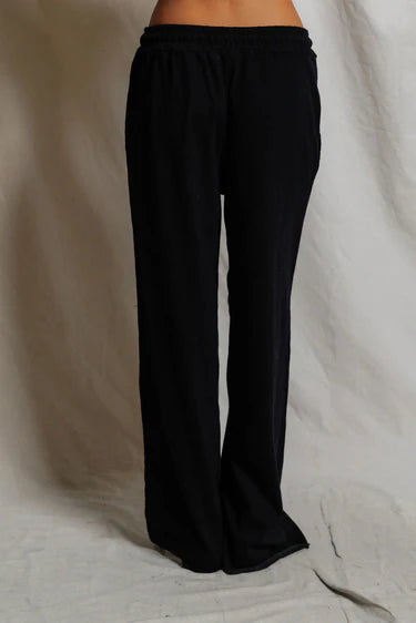 Black wide-leg pants on a neutral background