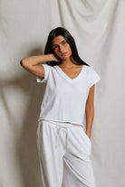 Woman wearing a white outfit against a plain background