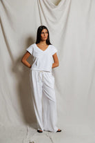 Woman wearing a white outfit against a plain background