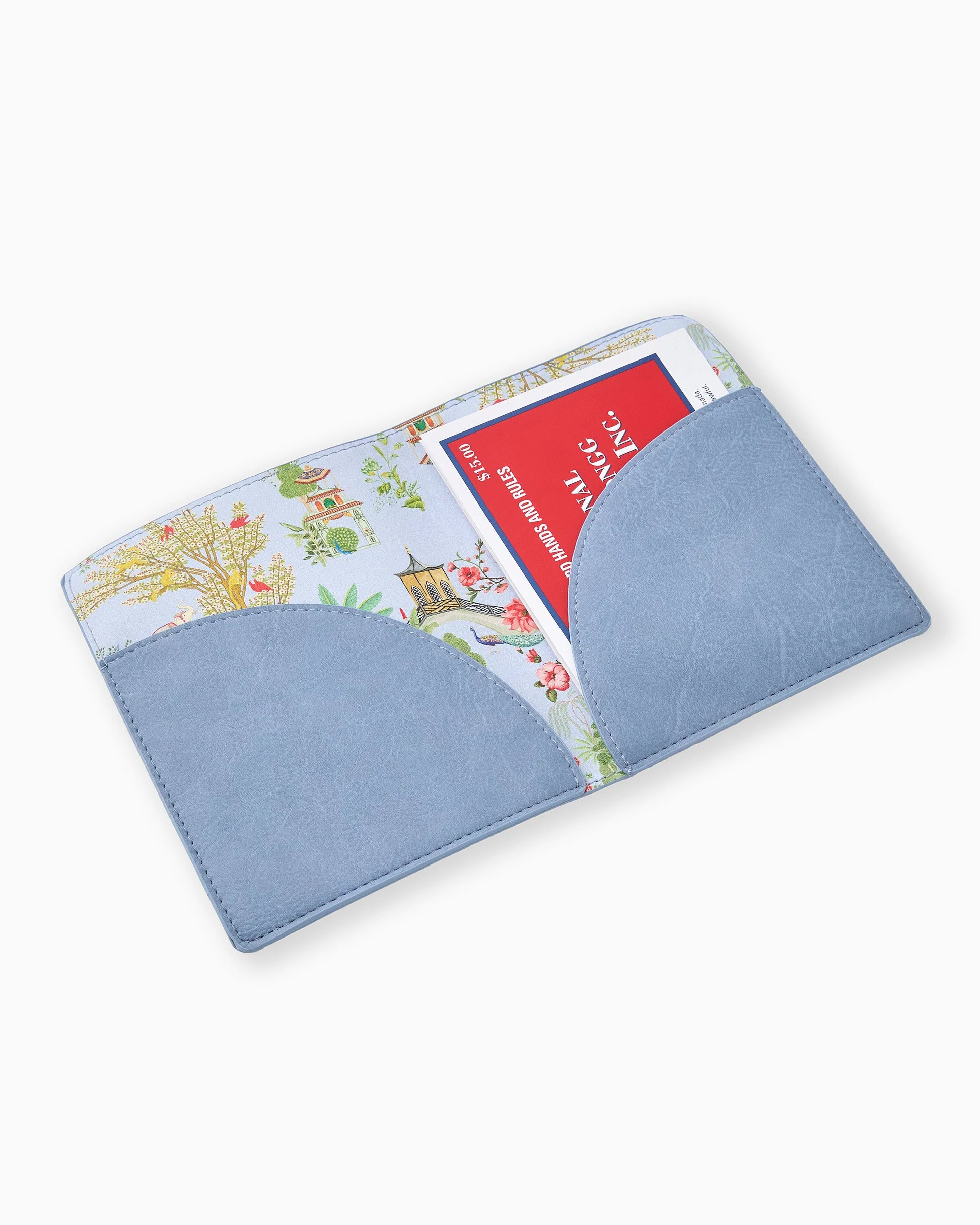 A light blue faux-leather card holder wallet with a floral toile patterned interior, shown open with a red credit card partially inserted, on a clean white background.
