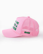 Pink cap with green text on a white background