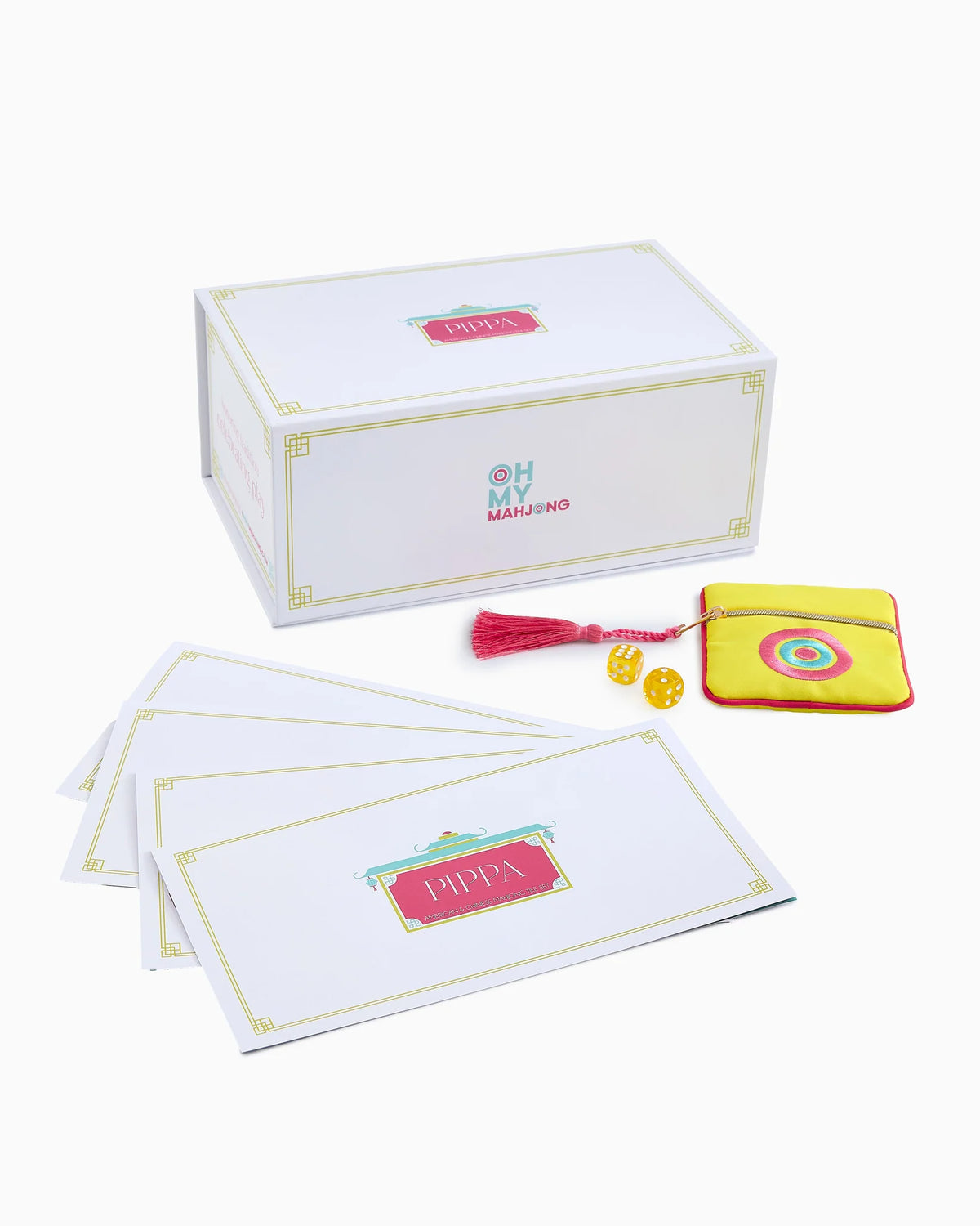 A boxed card game set on a light gray background, including a white box with gold trim, several white cards with pink and gold labels, a small yellow pouch with a red tassel, and two yellow dice.