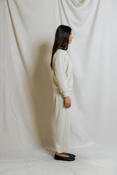 Person wearing a white outfit standing against a plain white background