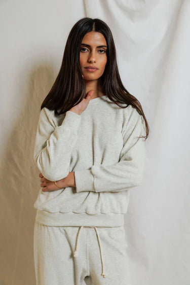 Woman wearing a beige tracksuit against a plain background