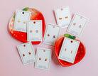 Earring cards with earrings on a pink background