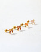 Gold bow-shaped earrings on a white background