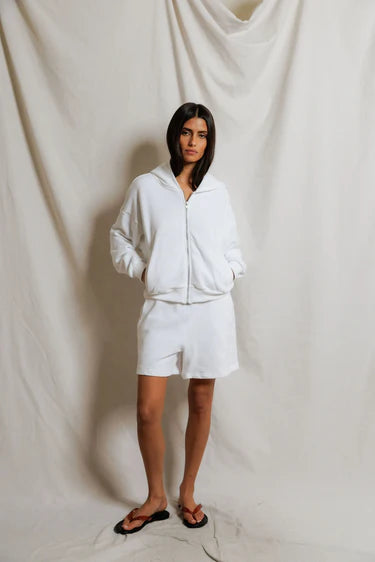 Person wearing a white tracksuit against a plain background