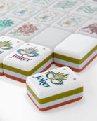 Close-up of decorative tiles with 'joker' and floral designs on a white surface.