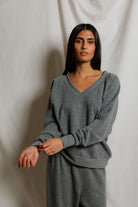Woman wearing a gray outfit against a plain background
