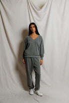 Person wearing a gray tracksuit against a plain background
